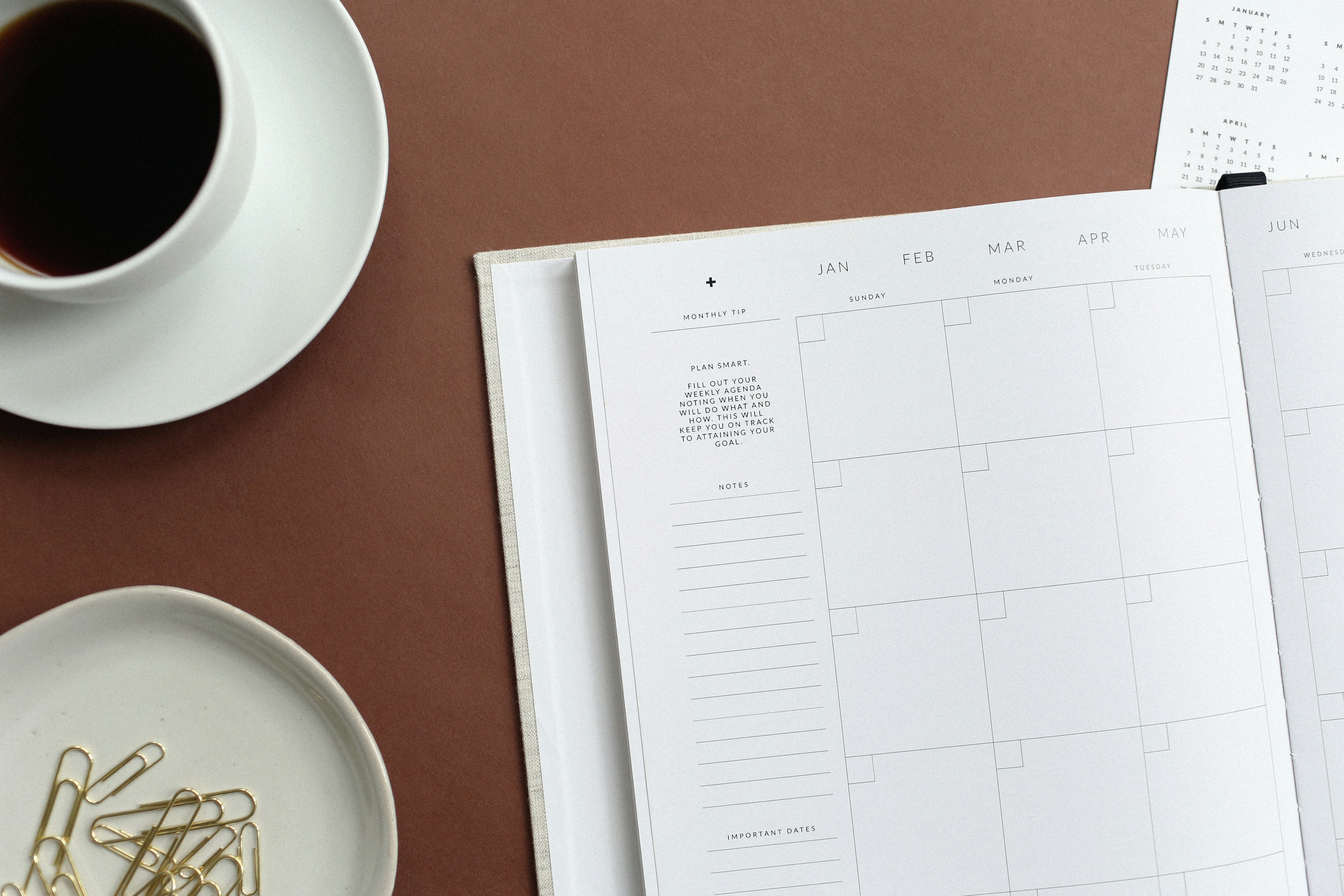 Open planner and cup of tea arranged on a cozy desk